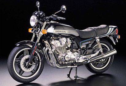 Honda motorcykel, modell med klassisk design, förkromade avgasrör och svart sadel, framför svart bakgrund.