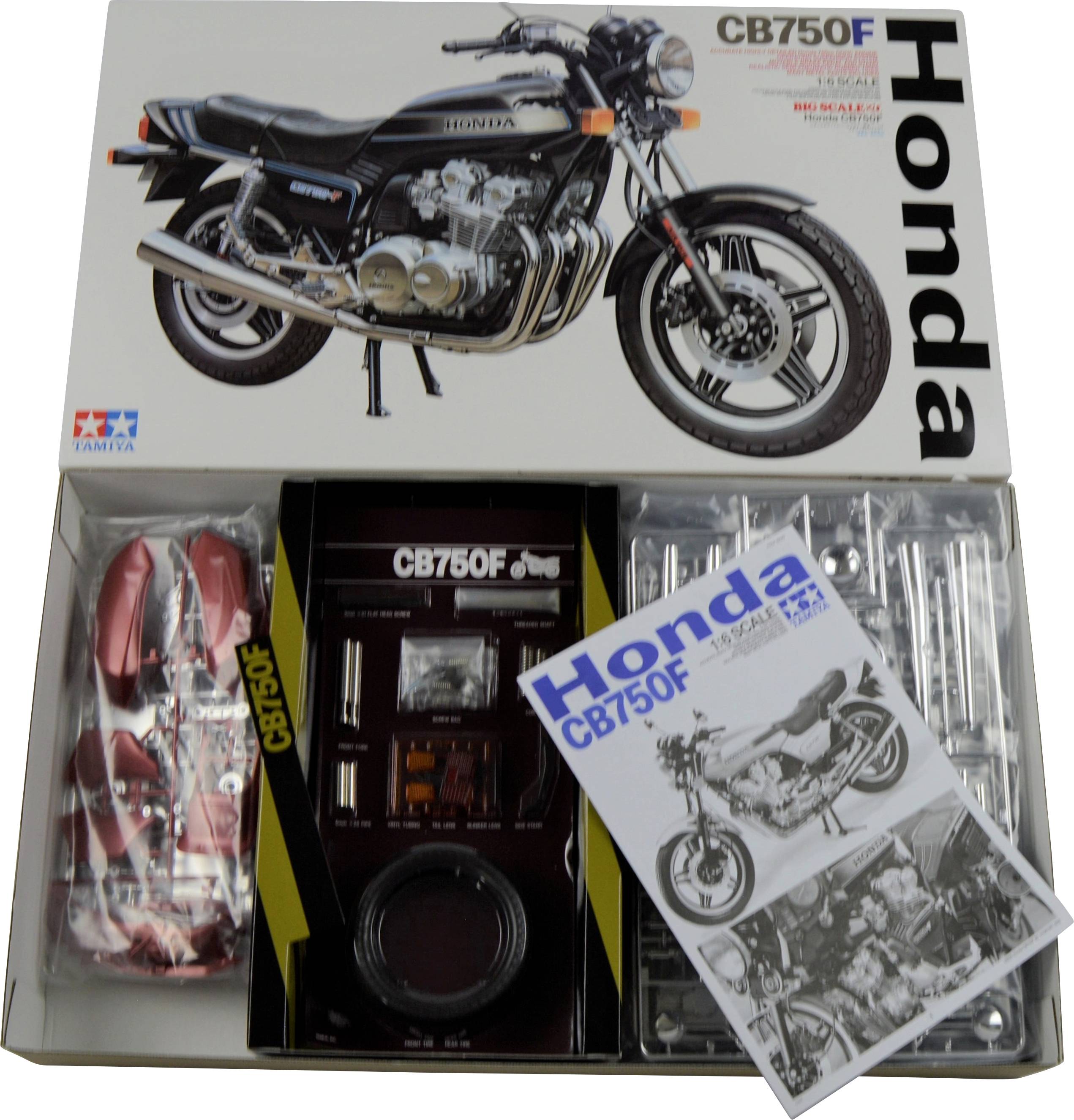 Modellbyggsats för Honda CB750F från Tamiya, bestående av delar och en instruktionsbok. Bild av motorcykeln på förpackningen.