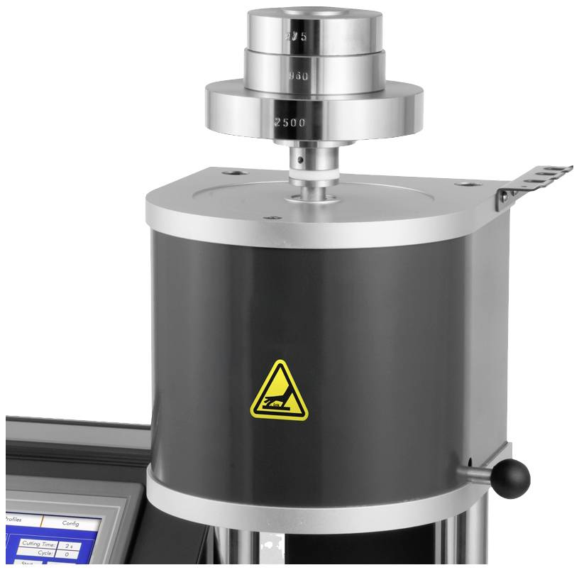 En modern laboratorieutrustning för materialtester med ett cylinderformat fäste och en digital display, placerad på ett bord.