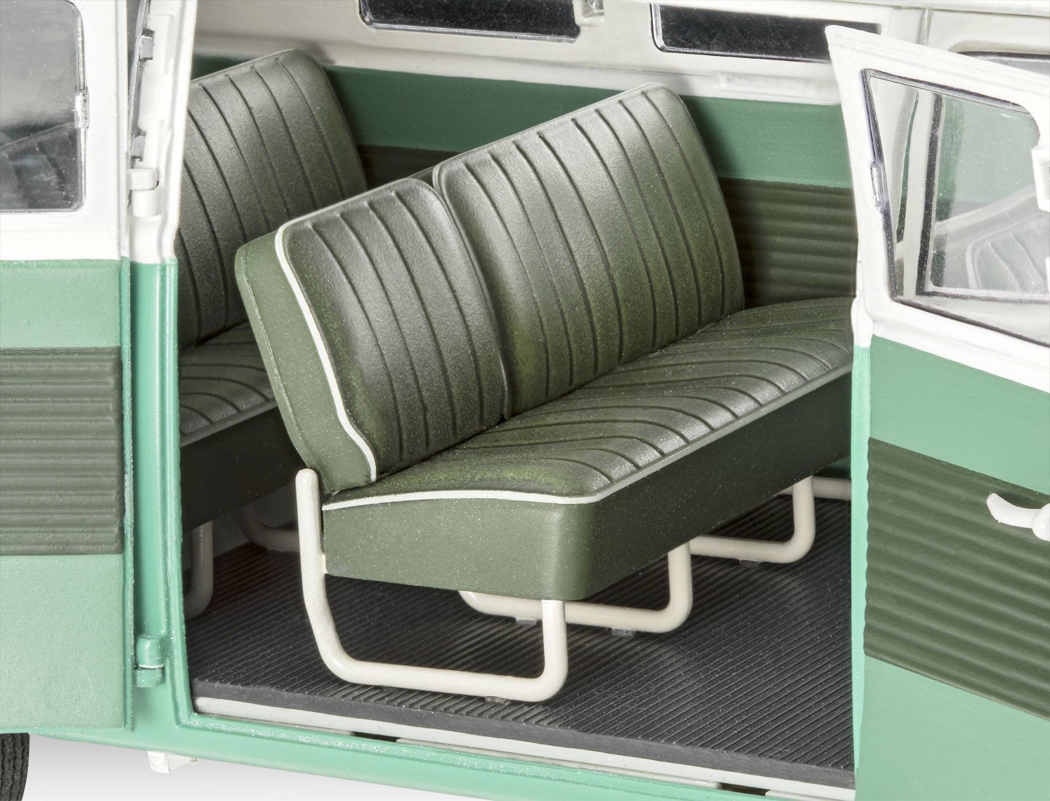 En öppen dörr till en grön, klassisk skåpbil visar en bänk med grönt läder och vita ränder invändigt.