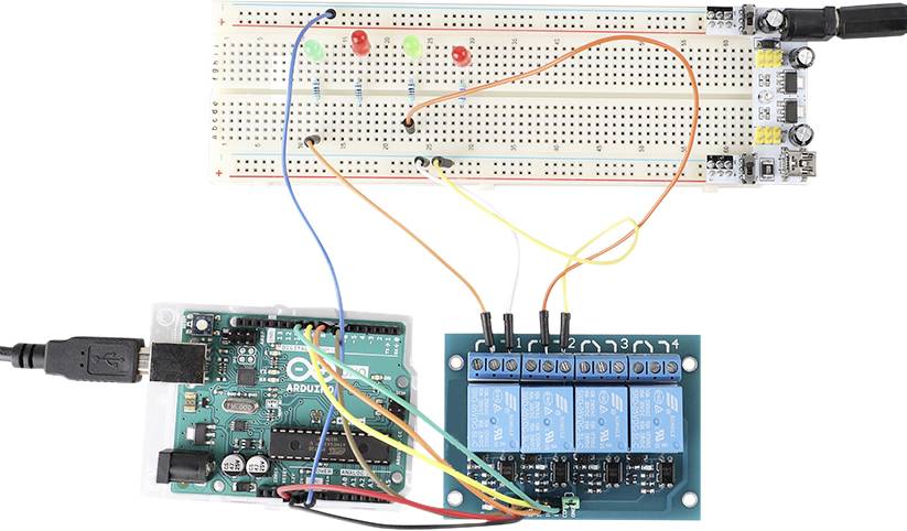 Arduino-mikrokontroller ansluten till ett kopplingsbräde och ett relämodul. Olika trådar förbinder LED-lampor och komponenter.