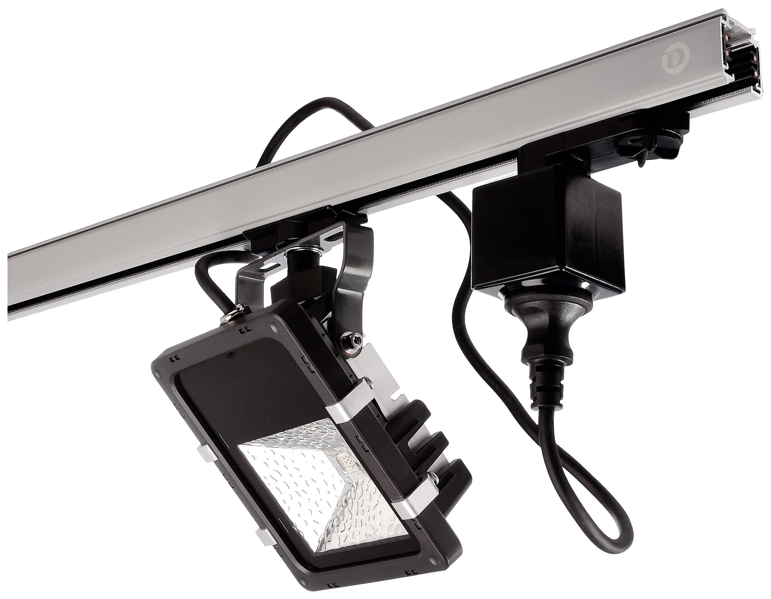 En svart LED-strålkastare är fäst vid en silvergrå skena. En svart kabel förbinder lampan med strömförsörjningen.