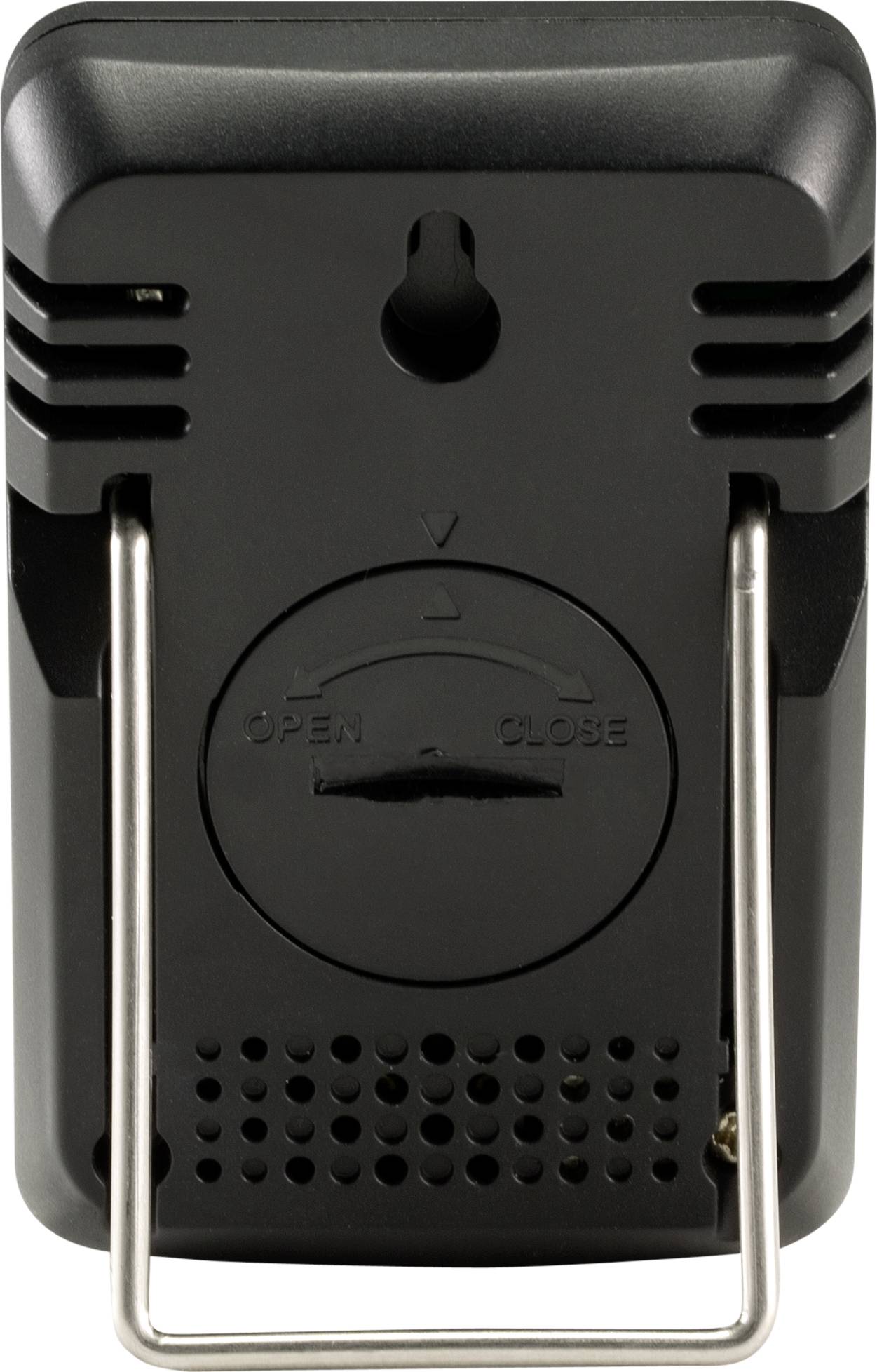 Svart, rektangulärt enhetsapparat med upphängningsanordning och ventilationsöppningar, visar ett batterifack med pilriktningsmarkeringar.