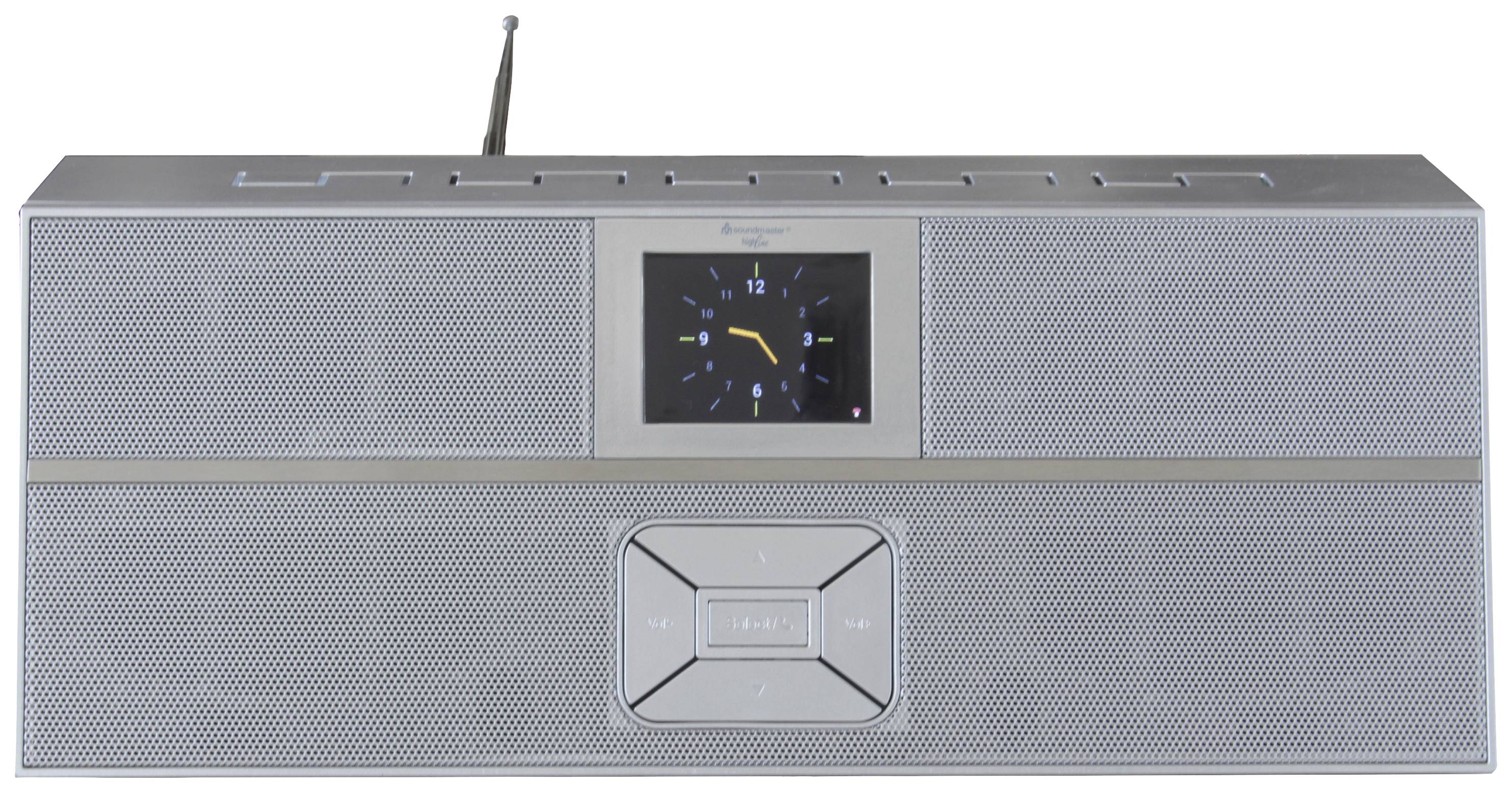 En silvergrå radioapparat med antenn och inbyggd klocka i mitten. Klockan visar 10:10.