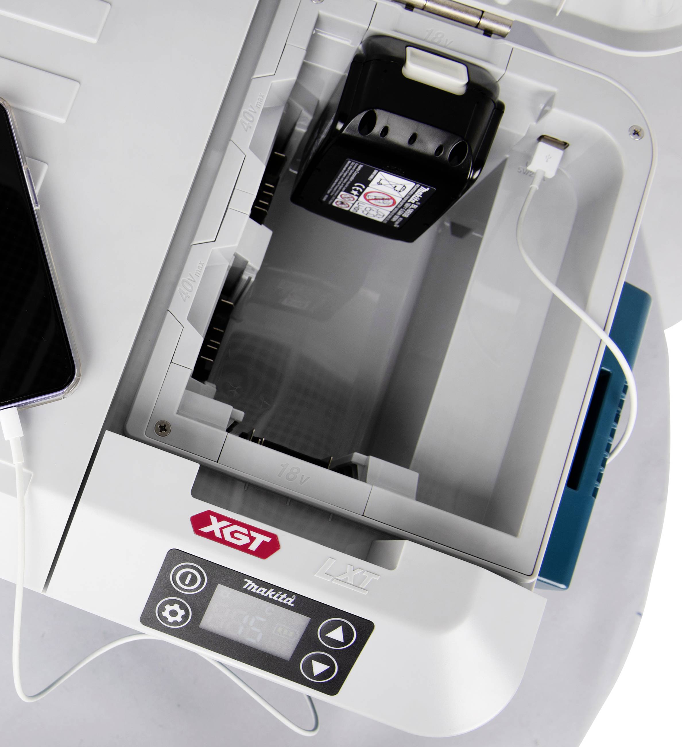 Laddare med batteri, USB-kabel ansluten, på vit yta.