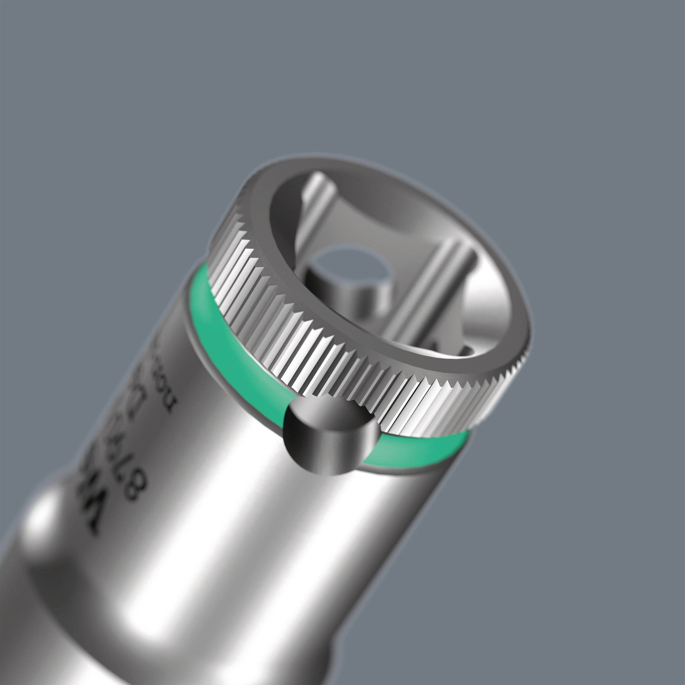 En metallisk cylindrisk apparat med grön ring, avsedd för att skruva fast mekaniska delar, mot en grå bakgrund.