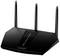 Svart WLAN-router med tre antenner. Modell 'Nighthawk'. Enheten visar statuslampor och är avsedd för trådlös nätverksströmning.