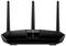 En svart WiFi-router med tre antenner, centralt placerad på ett bord. Enheten visar lysande kontrollampor på framsidan.