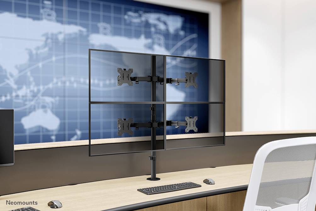 Ett skrivbord med ett monitorfäste för fyra skärmar, med en världskarta i bakgrunden och modernt design.