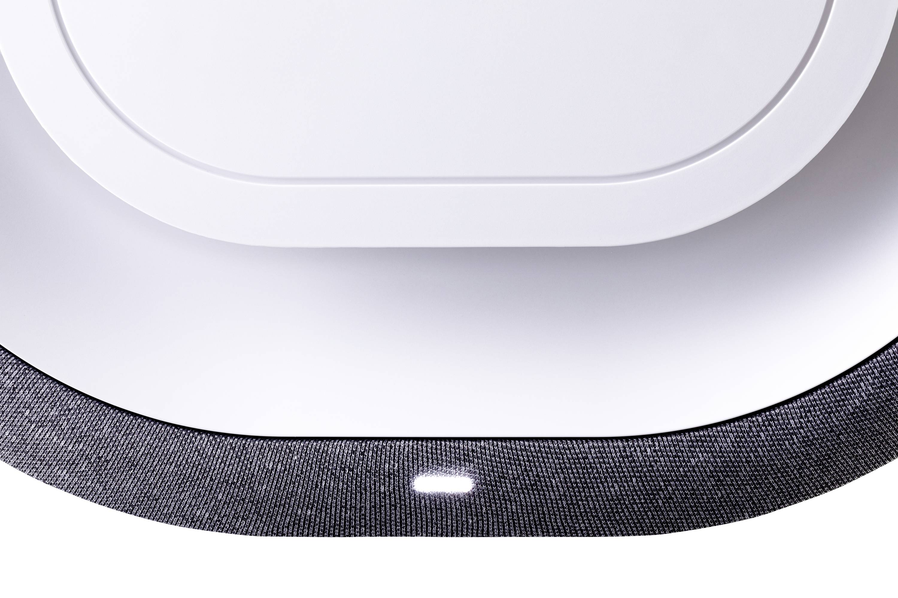 En intelligent högtalare med rundad, vit design och lysande LED-indikator på framsidan som visar modern stil.