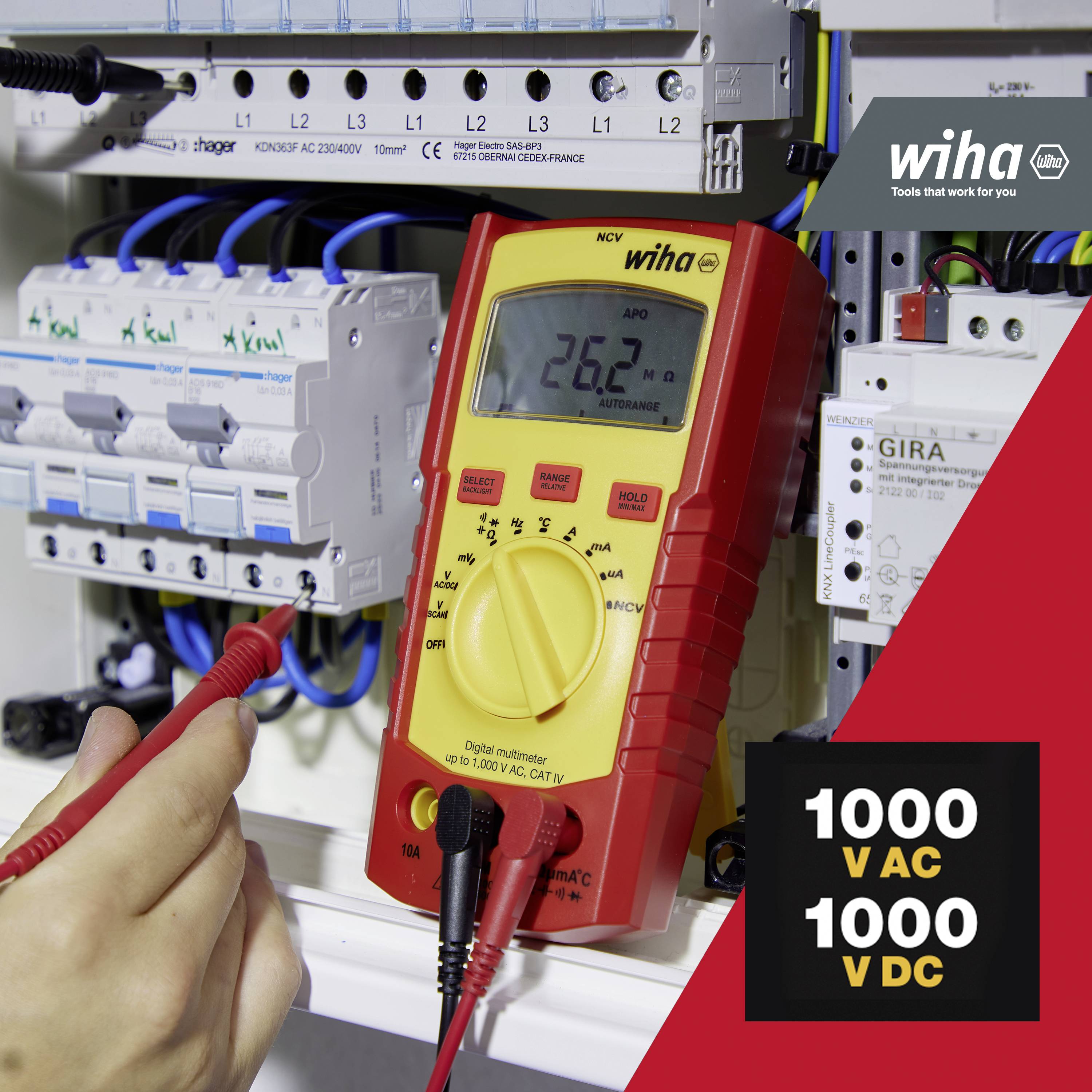 Person mäter med multimeter vid elcentral. Display: 260 V. Grafik: '1000 V AC, 1000 V DC'. Varumärke Wiha synligt.