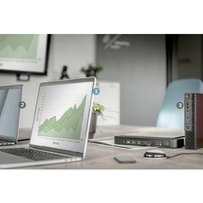 En laptop med ett diagram som visar en stigande trend. Bredvid ytterligare en laptop och en teknisk apparat på ett bord.