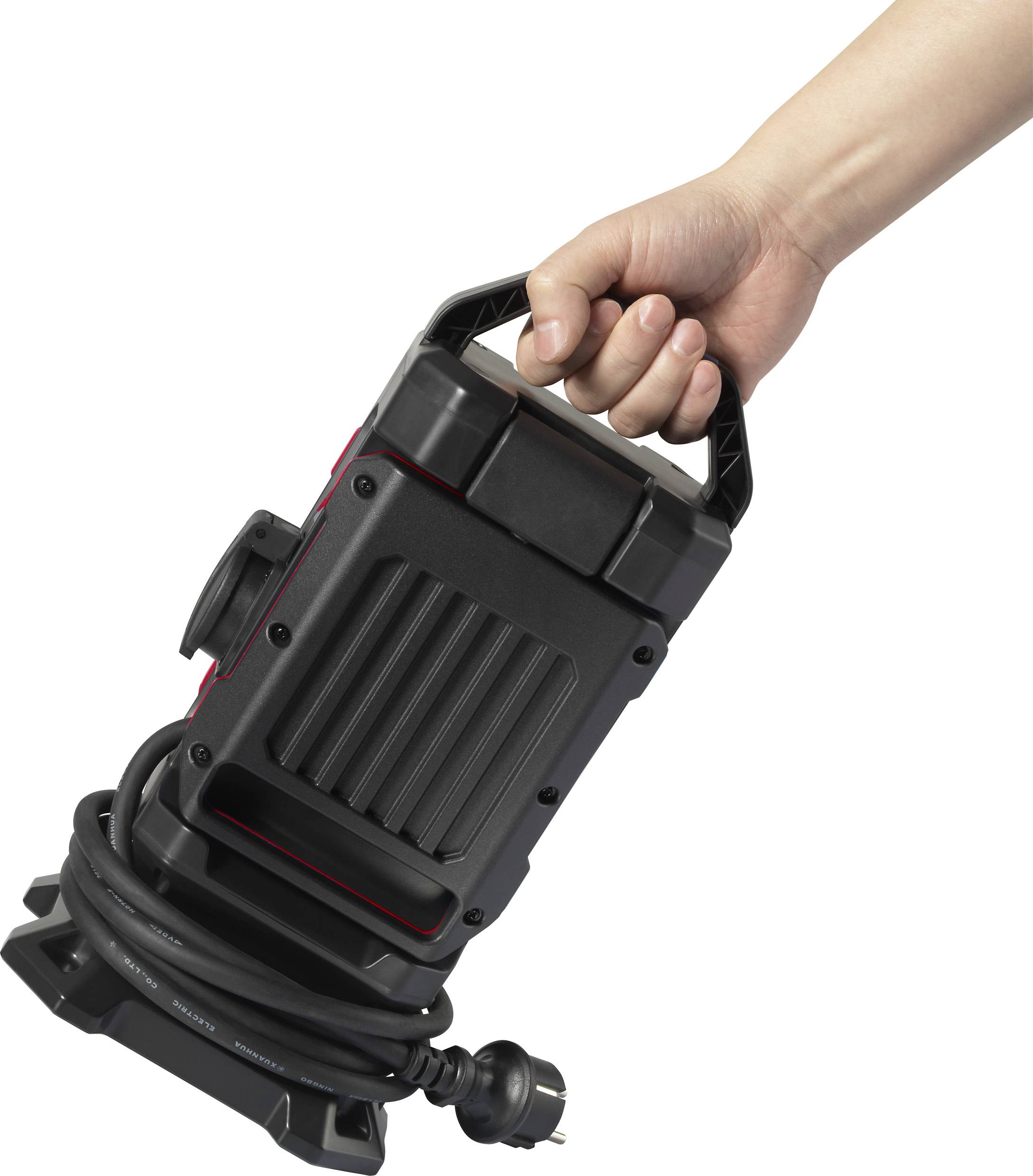 En hand håller en svart, bärbar vattenpumpsmotor med en lång kabel, redo att användas i vattenrelaterade tillämpningar.