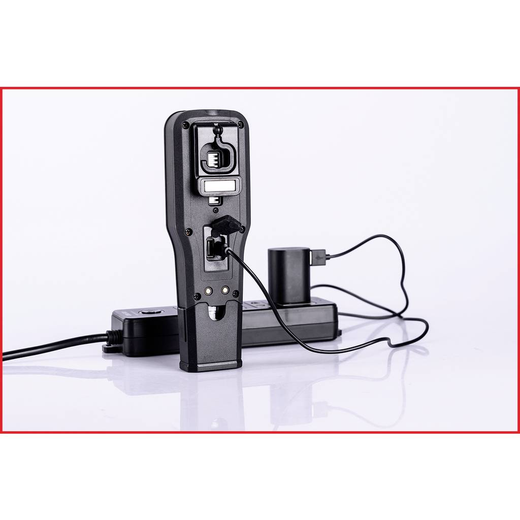 En laddare med flera anslutningar som är ansluten till en nätadapter. En USB-kabel är inkopplad och förser en enhet med ström.