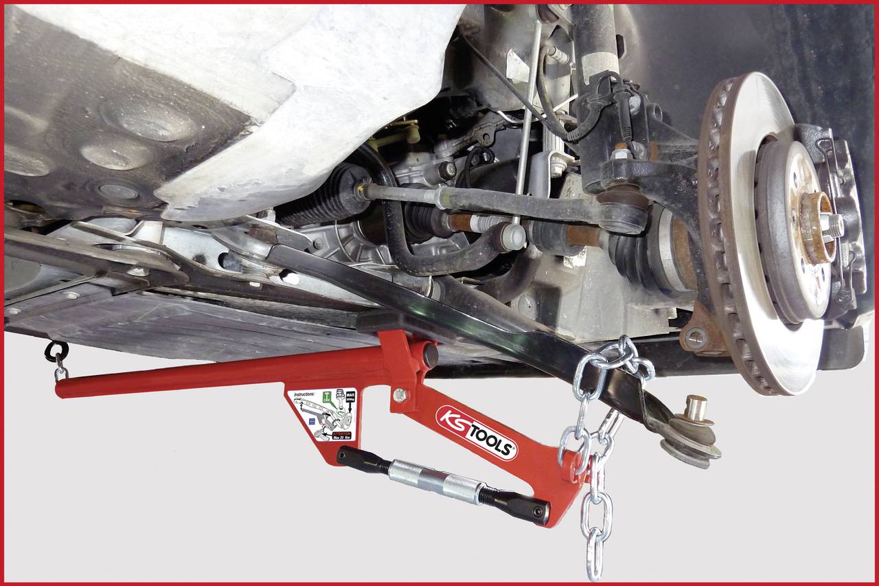 Fordon upphissat, med hjulupphängningen synlig. Ett rött verktyg stabiliserar hjullagerhuset på höger sida.