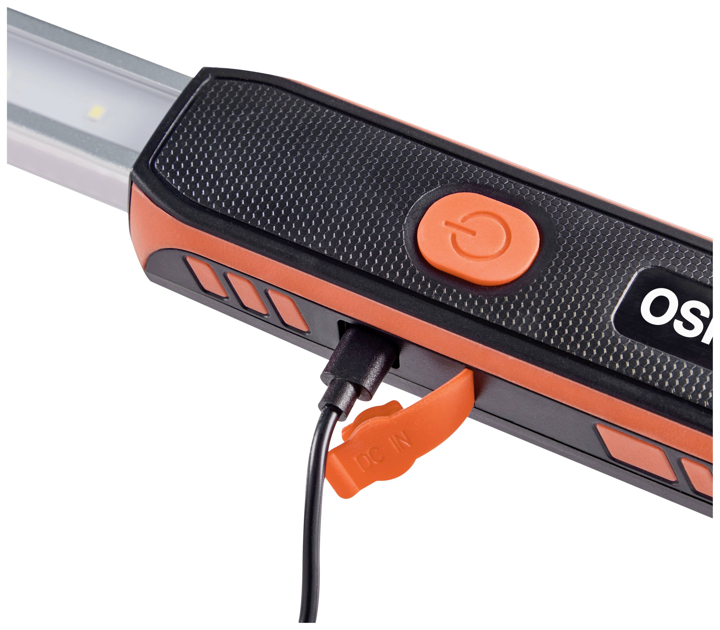 En laddare är inkopplad i en bärbar lampa. Den är svart och orange och har en strömknapp.