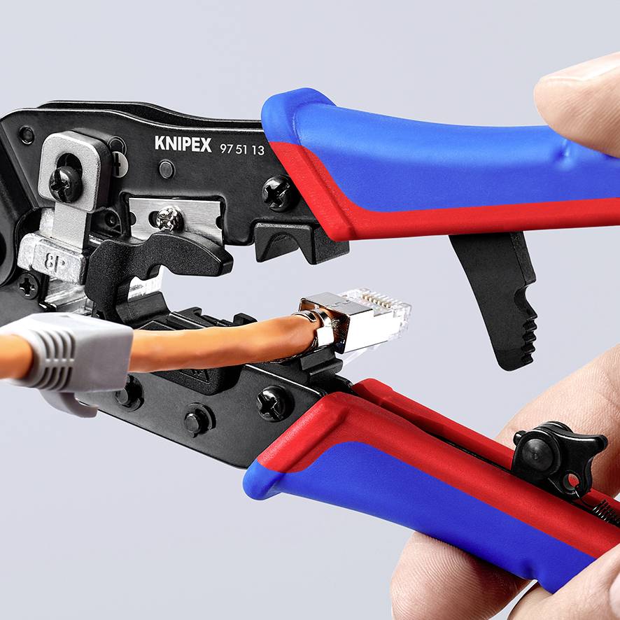 Knipex Crimpverktyg krymper en RJ45-kontakt på en nätverkskabel. Två händer håller verktyget för exakt arbete.