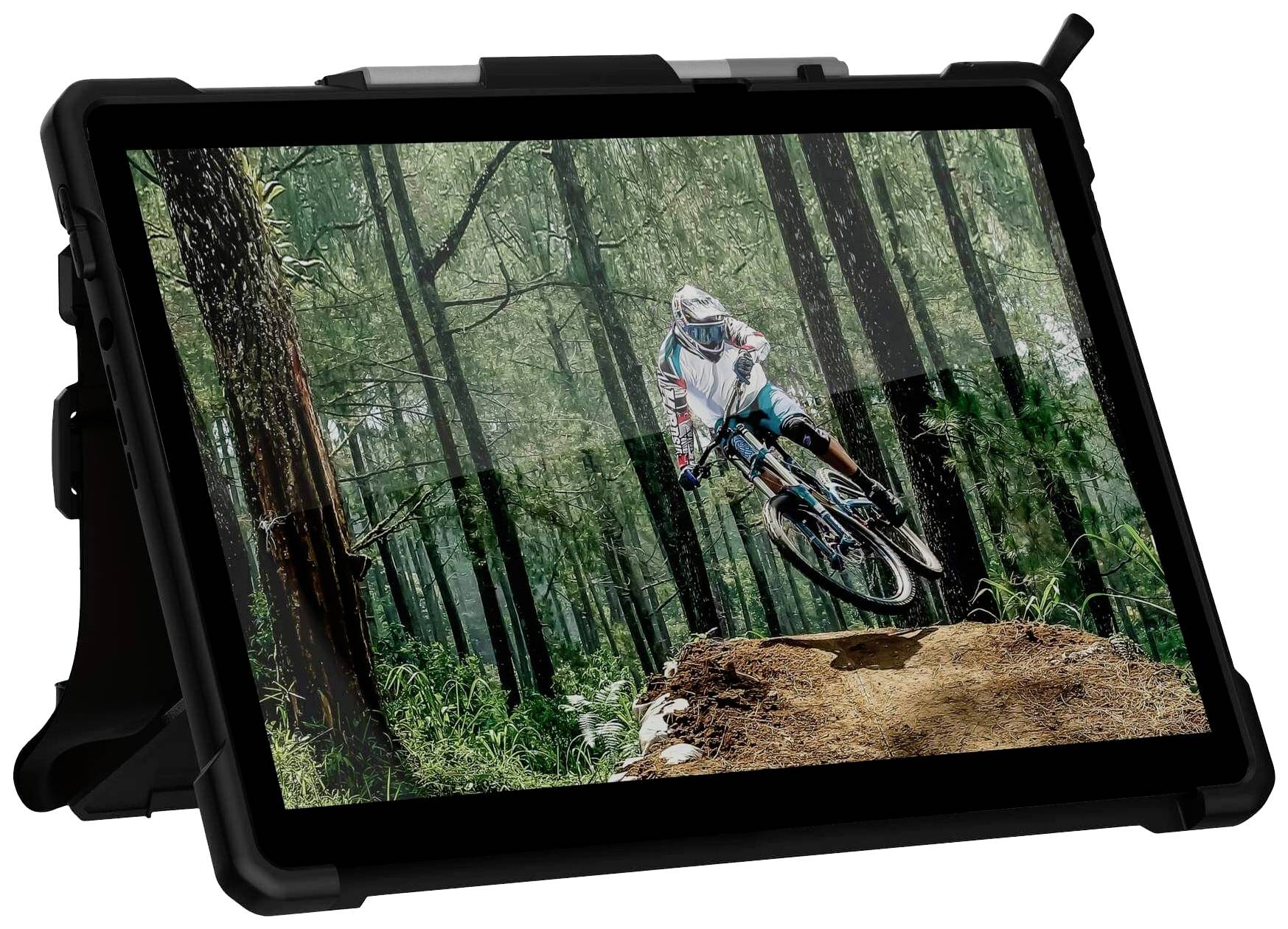 En mountainbikecyklist i färgglada kläder åker över en förhöjning i en tät, grön skog. Bilden visar en spännande handling.