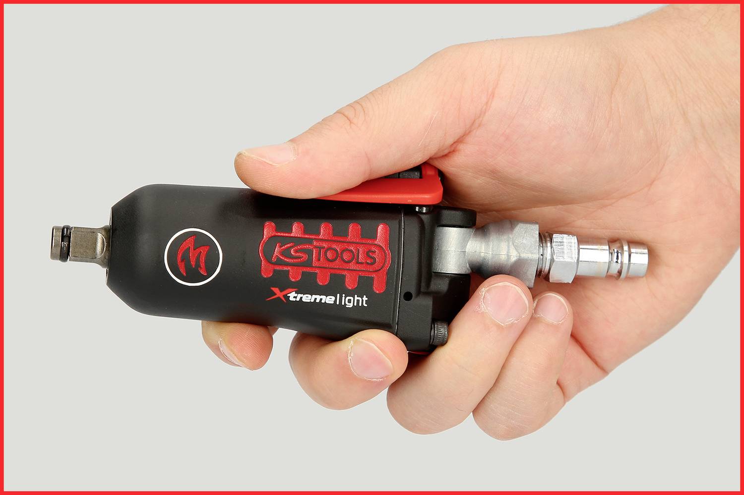 En hand som håller ett svart KS Tools tryckluftsverktyg med röd text 'Xtreme light'. Det är en kompakt enhet med anslutning.