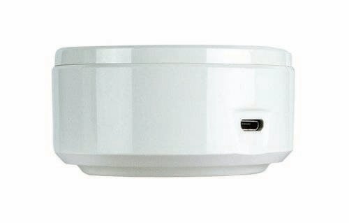En vit, rund elektronisk enhet med en USB-port på höger sida. Den står på en plan yta.