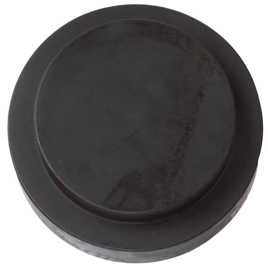 En svart ishockeypuck ligger på en vit yta och symboliserar vintersporter eller sporter på is.