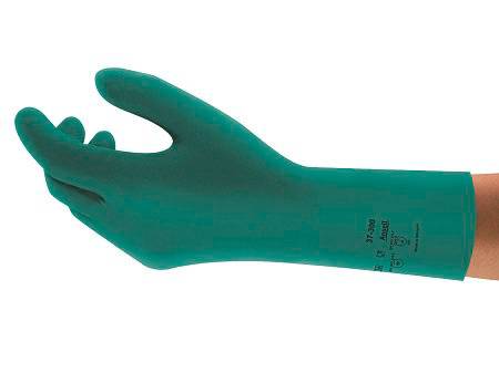 En person bär en grön skyddshandske som är lämplig för hantering av kemikalier. Handsken har markeringar och symboler.