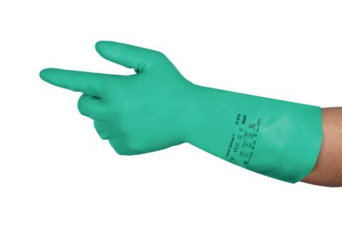 En hand i en grön gummihandske pekar åt vänster. Handsken har tryck med standarder och storleksangivelser.