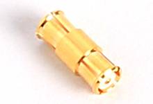 En liten guldfärgad metallkontakt på vit bakgrund, möjligen en koaxial adapterkontakt.