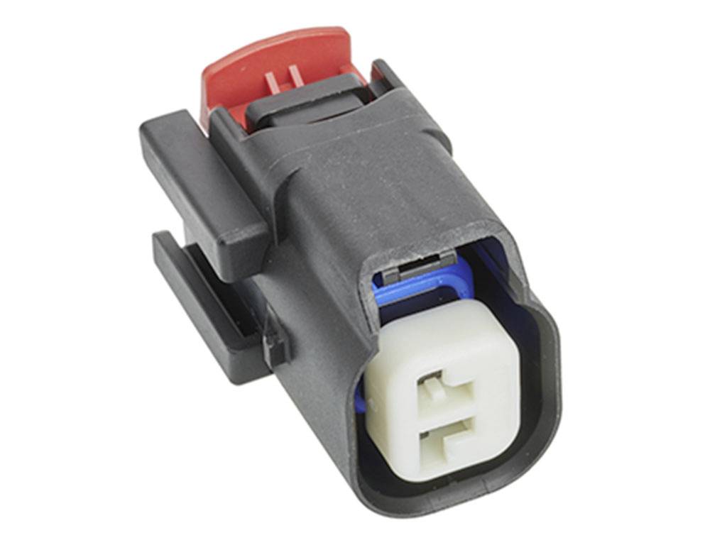 En svart och röd elektrisk kontakt med ett vitt anslutningsdon som används i tekniska apparater.