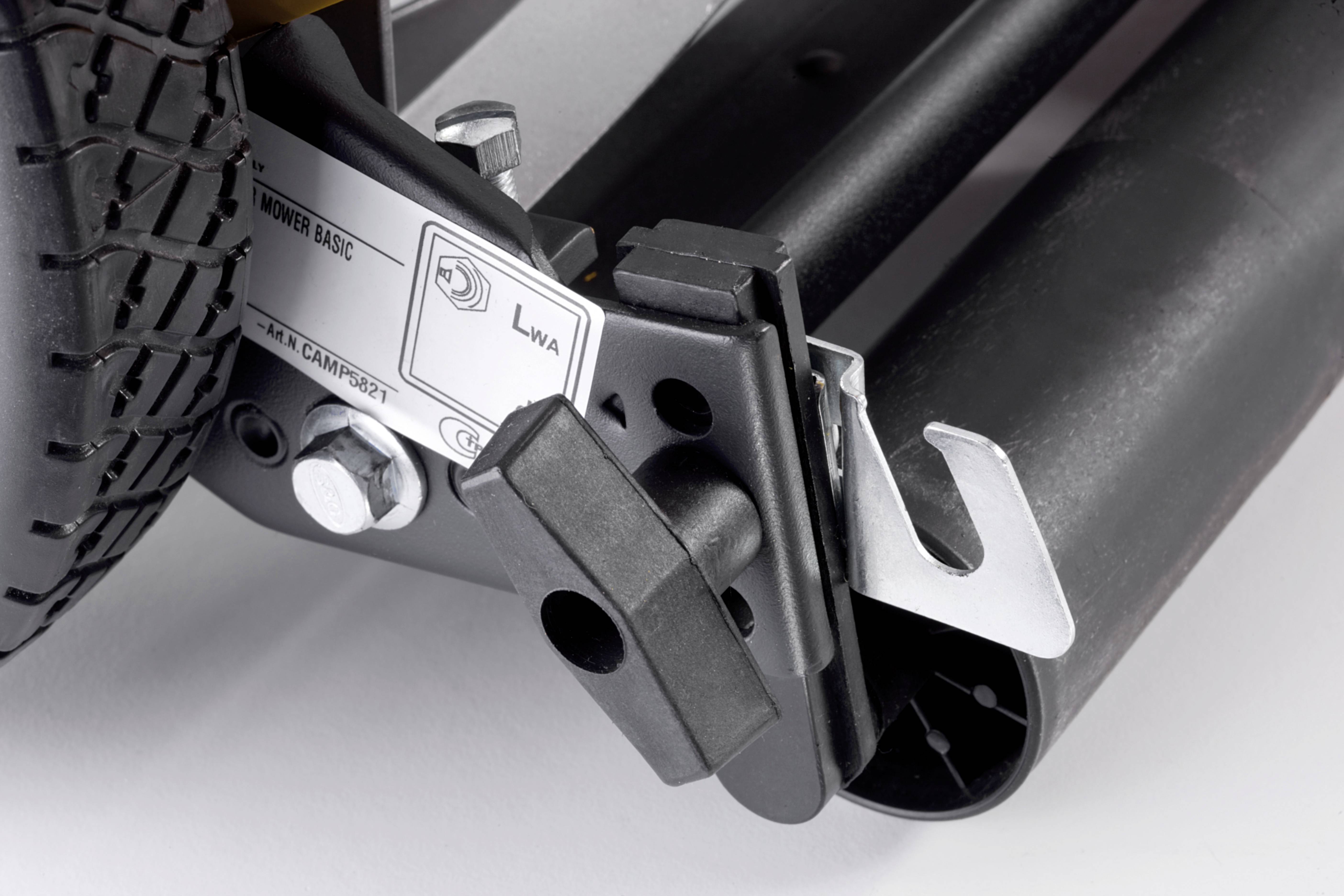 Närbild av en mekanisk komponent med ett hjul och en hävarm, med skyltar märkta 'LWA'.