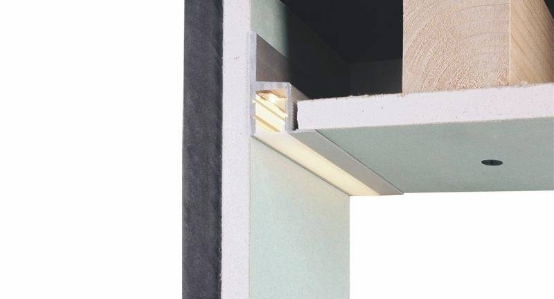 Ett vertikalt snitt av ett möbelstycke visar detaljer av trästruktur, förbindelselement och materialskikt.