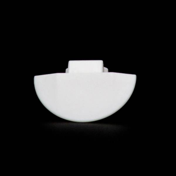 Ett halvrundat, vitt föremål framför en svart bakgrund. Det ser ut som ett litet, minimalistiskt, geometriskt objekt.