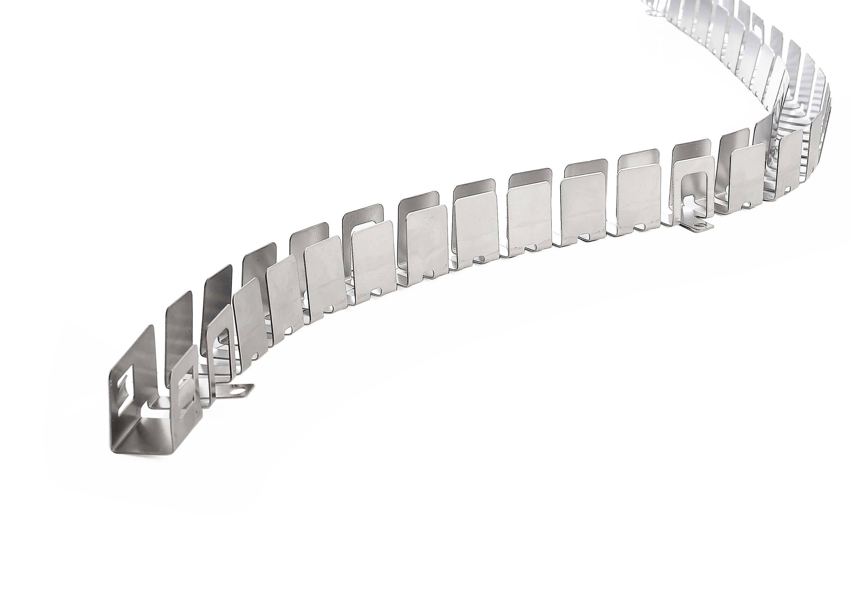 En silver, metallisk kabelkanal med rektangulära segment slingrar sig uppåt till höger.