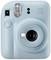 En ljusblå direktbildskamera, modell 'instax mini 12', med inbyggd blixt och 60 mm objektiv för närbild.