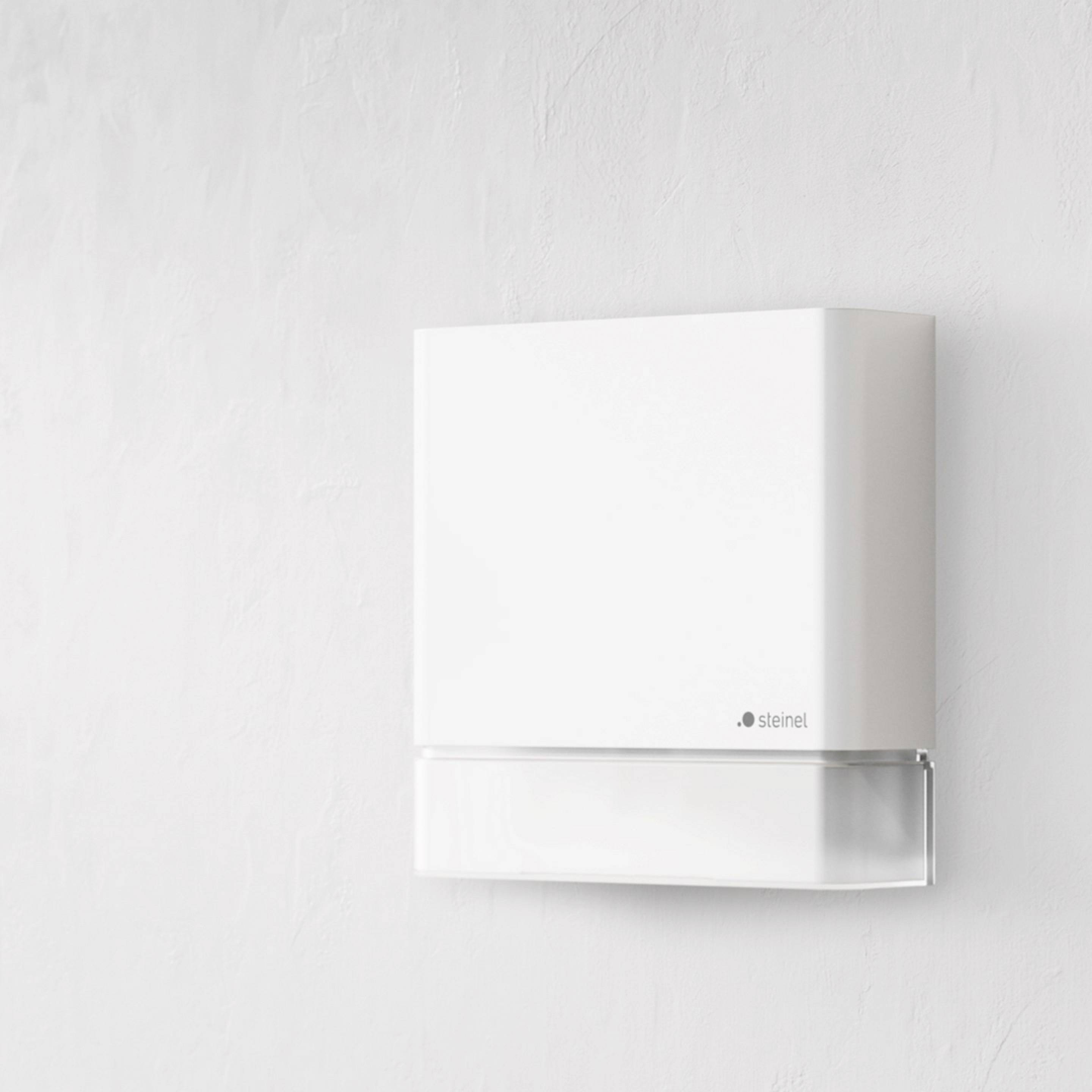 En vit, rektangulär LED-vägglampa med ett enkelt design, lämplig för moderna interiörer. Den är monterad på en ljus vägg.
