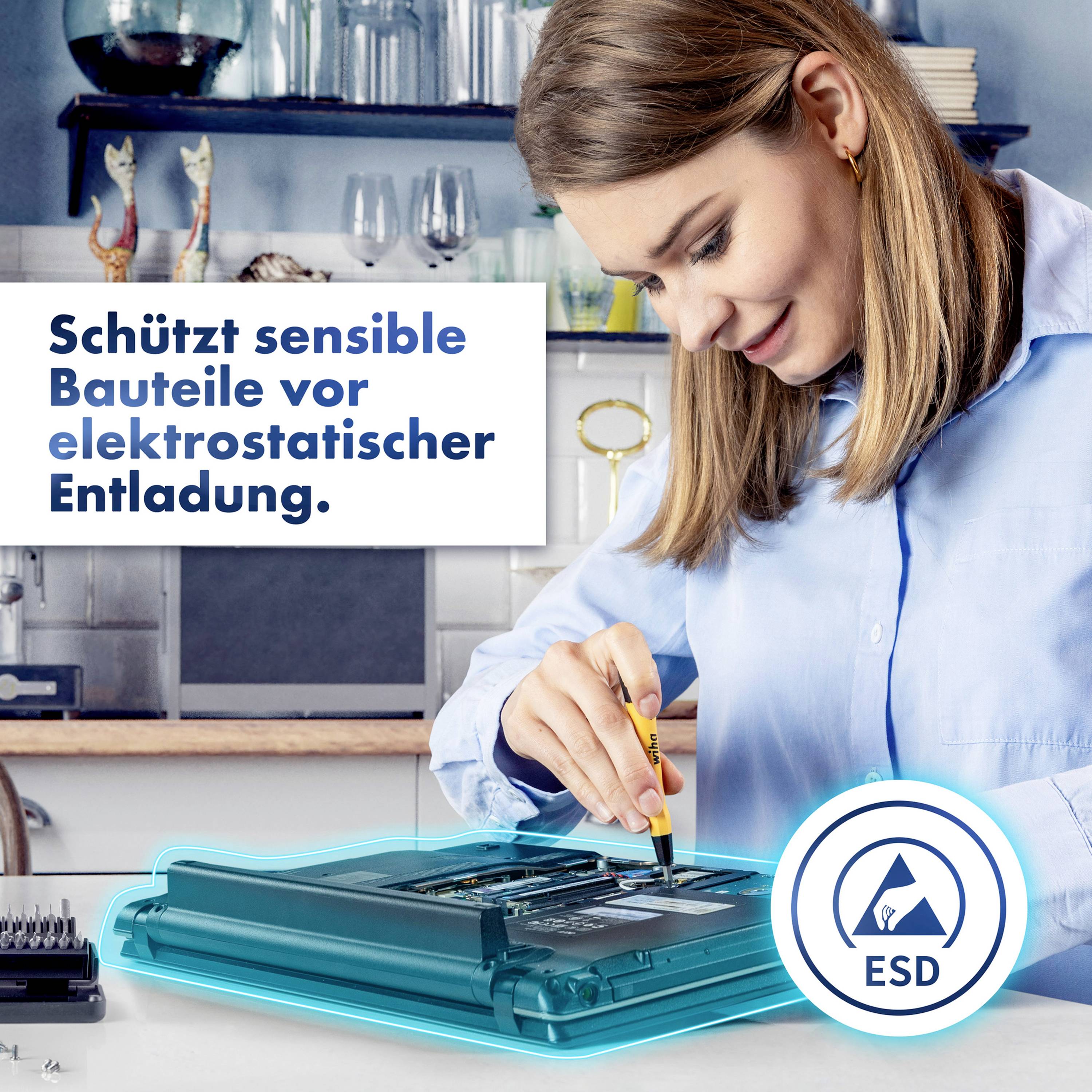 En kvinna i blå arbetskläder arbetar med ett verktyg på en elektronisk enhet. En skylt betonar skydd mot elektrostatisk urladdning.