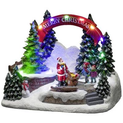 Julscen med en lysande 'God Jul'-båge, jultomten, en släde och barn bland upplysta granar.