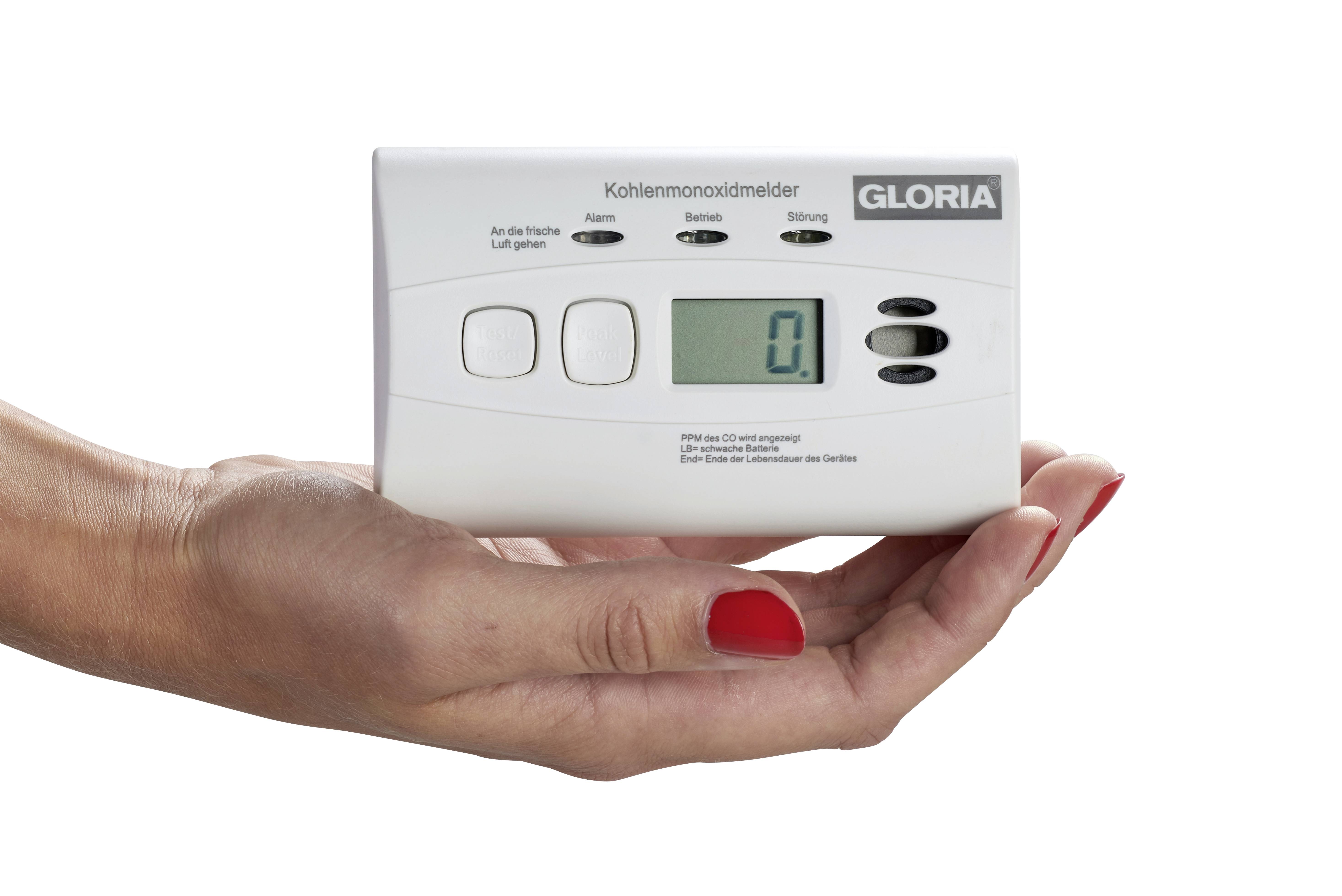 En hand håller en kolmonoxidvarnare med displayen '0', vilket indikerar att ingen kolmonoxid finns i omgivningen.