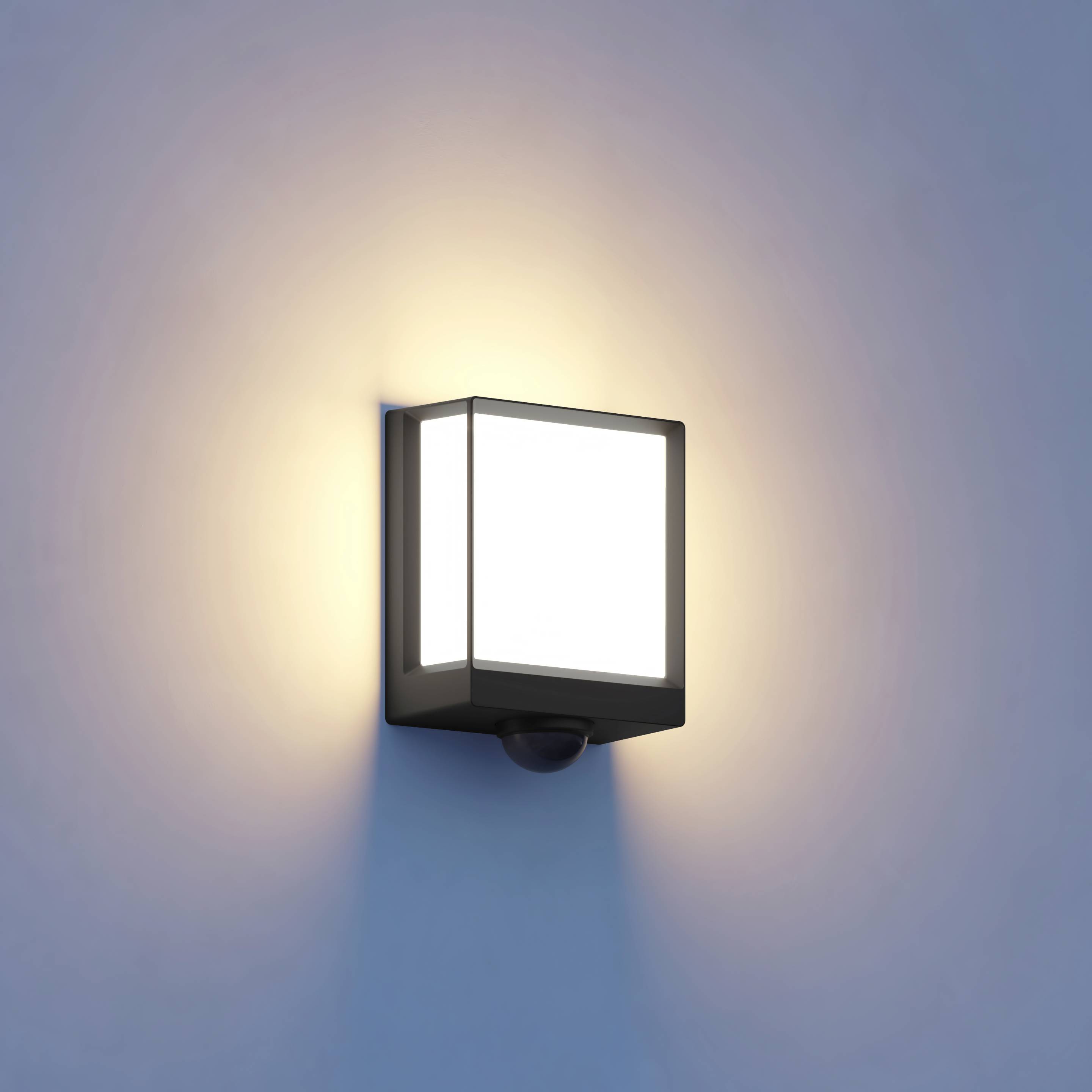 Vägglampa med varmt ljus monterad på en blå vägg, lyser uppåt och nedåt och skapar en mysig atmosfär.