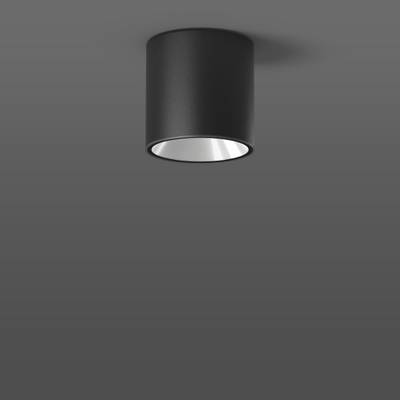 En svart, cylindrisk taklampa mot en grå vägg. Enkelt, modernt design för minimalistiska interiörer.