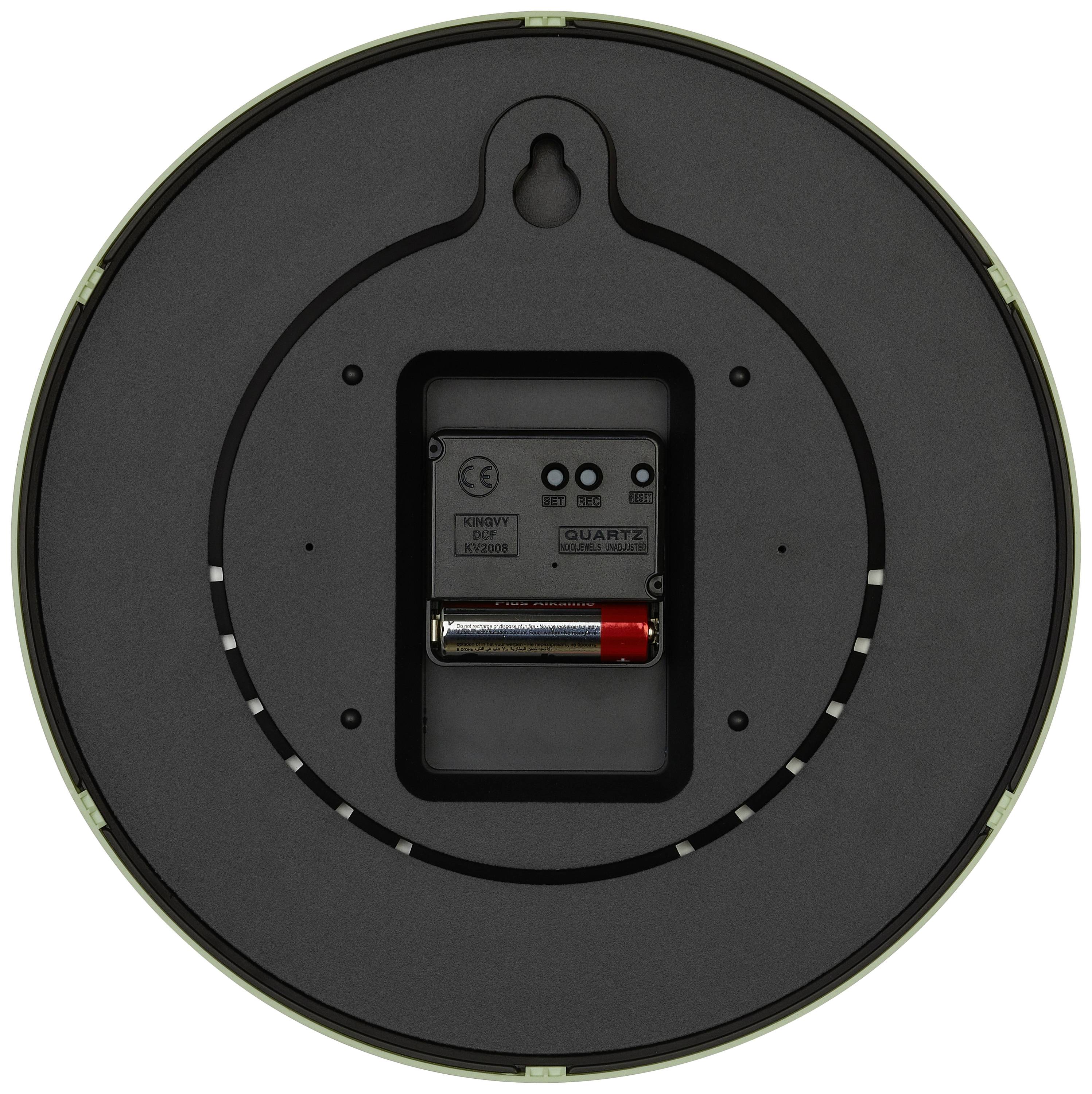 Baksidan av en rund väggklocka med batterifack. Ett AA-batteri är isatt. Visar upphängningspunkten och urverksdetaljer.