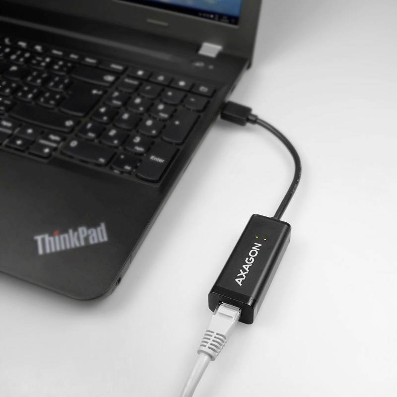 En bärbar dator med en ansluten 'AXAGON'-nätverksadapter; visar laptopanslutning via Ethernet-kabel.