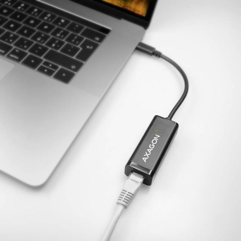 En bärbar dator är ansluten med en ethernetkabel via en 'AXAGON'-adapter.