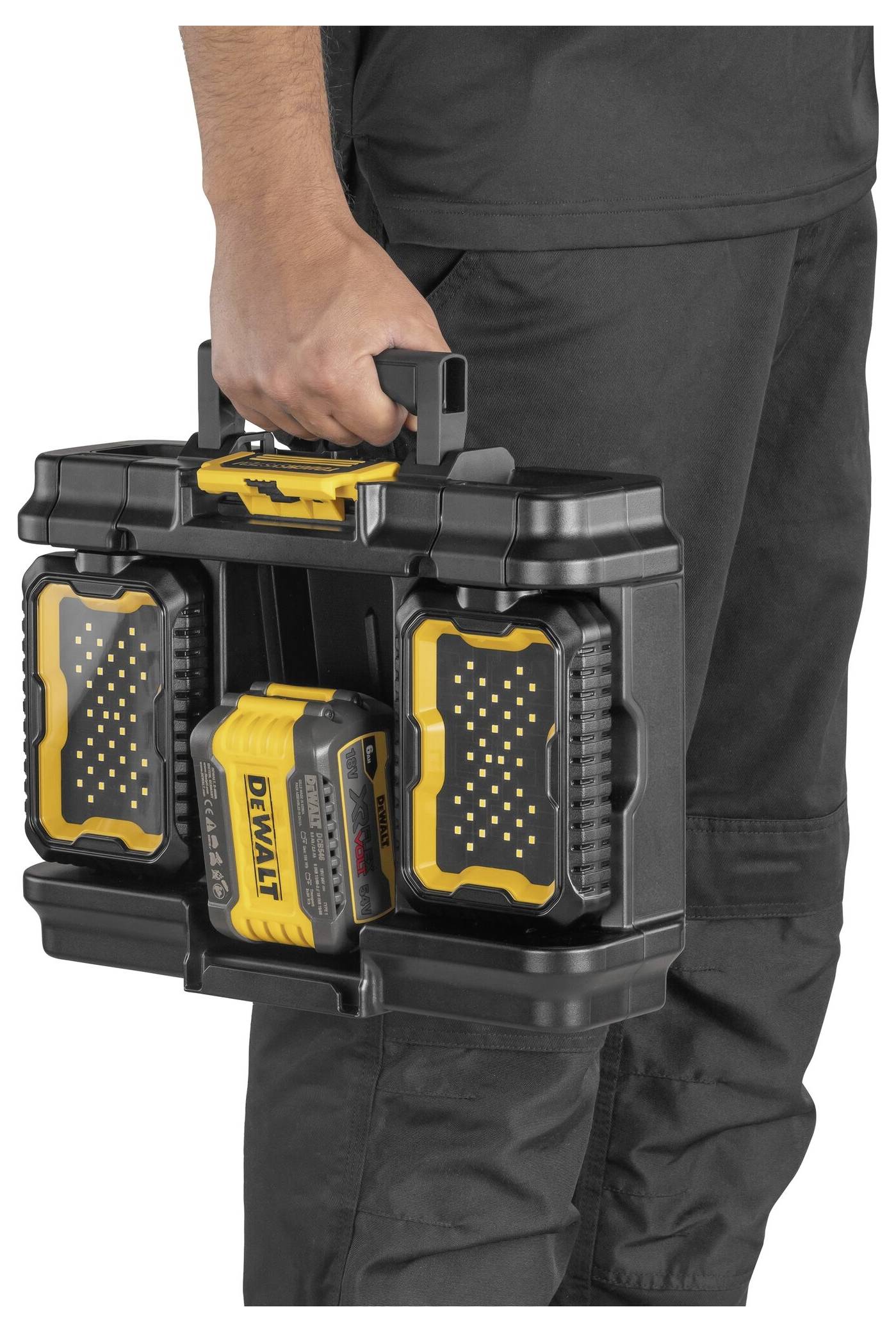 En person bär en svart verktygsväska med gula accenter och en laddare märkt 'DEWALT'.