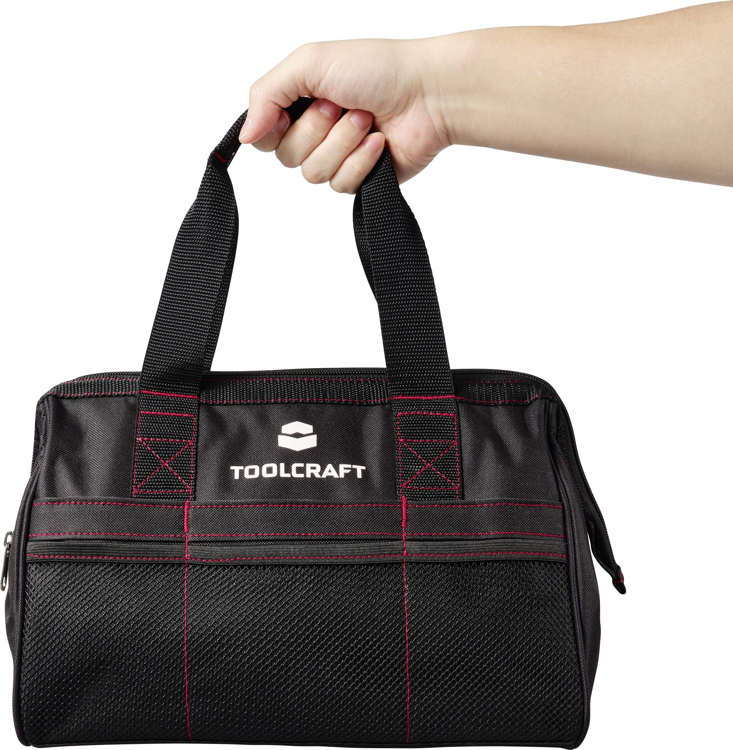 En hand håller en svart verktygsväska med röda sömmar och logotypen 'TOOLCRAFT' på framsidan.