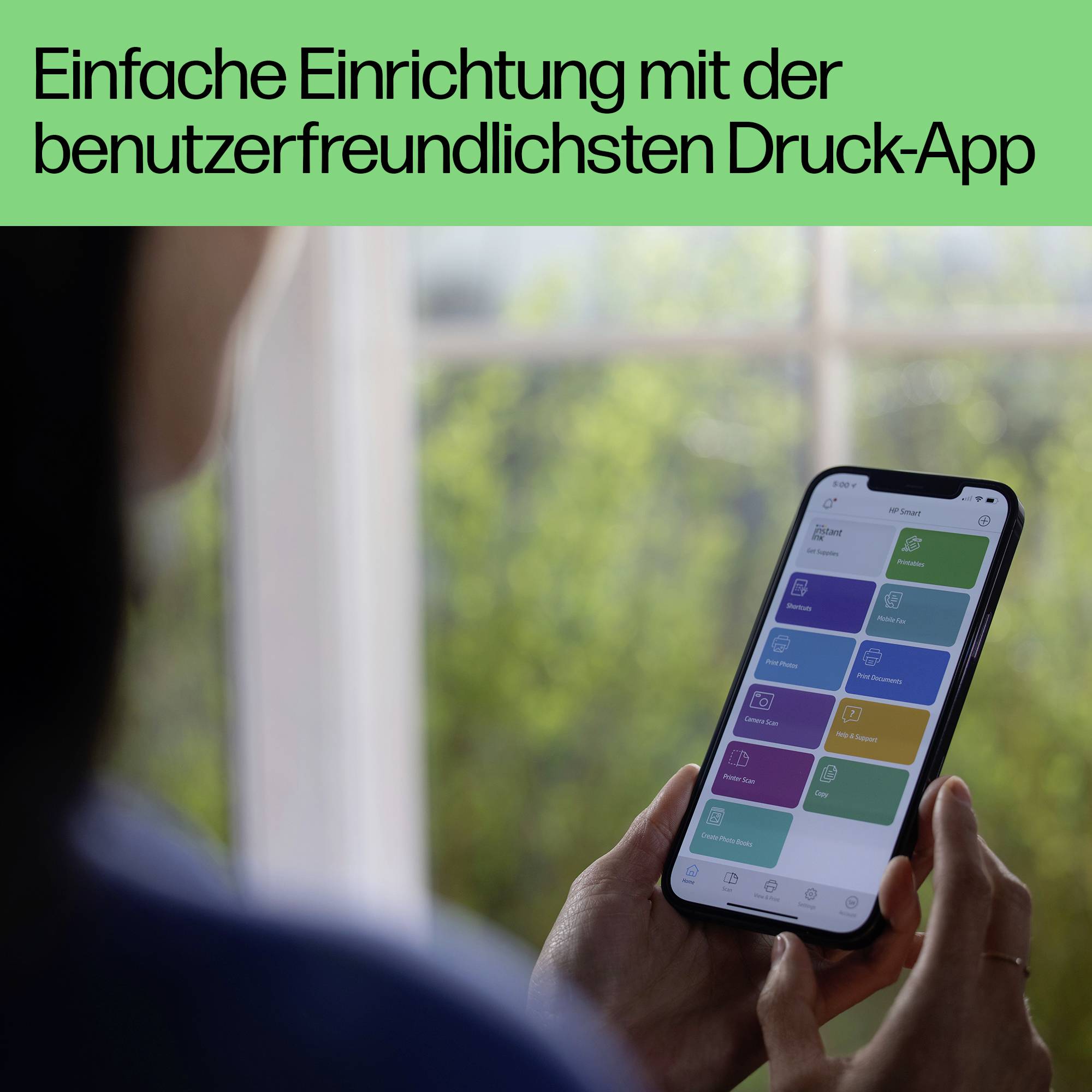 En person håller en smartphone med en öppen utskrifts-app; ett fönster syns i bakgrunden. Text: 'Enkel installation med den mest användarvänliga utskrifts-appen'.