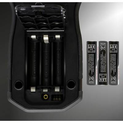 Ett öppet batterifack på en enhet som visar tre tomma AA-batterifack; bredvid finns tre AA-batterier på 1,5 V.