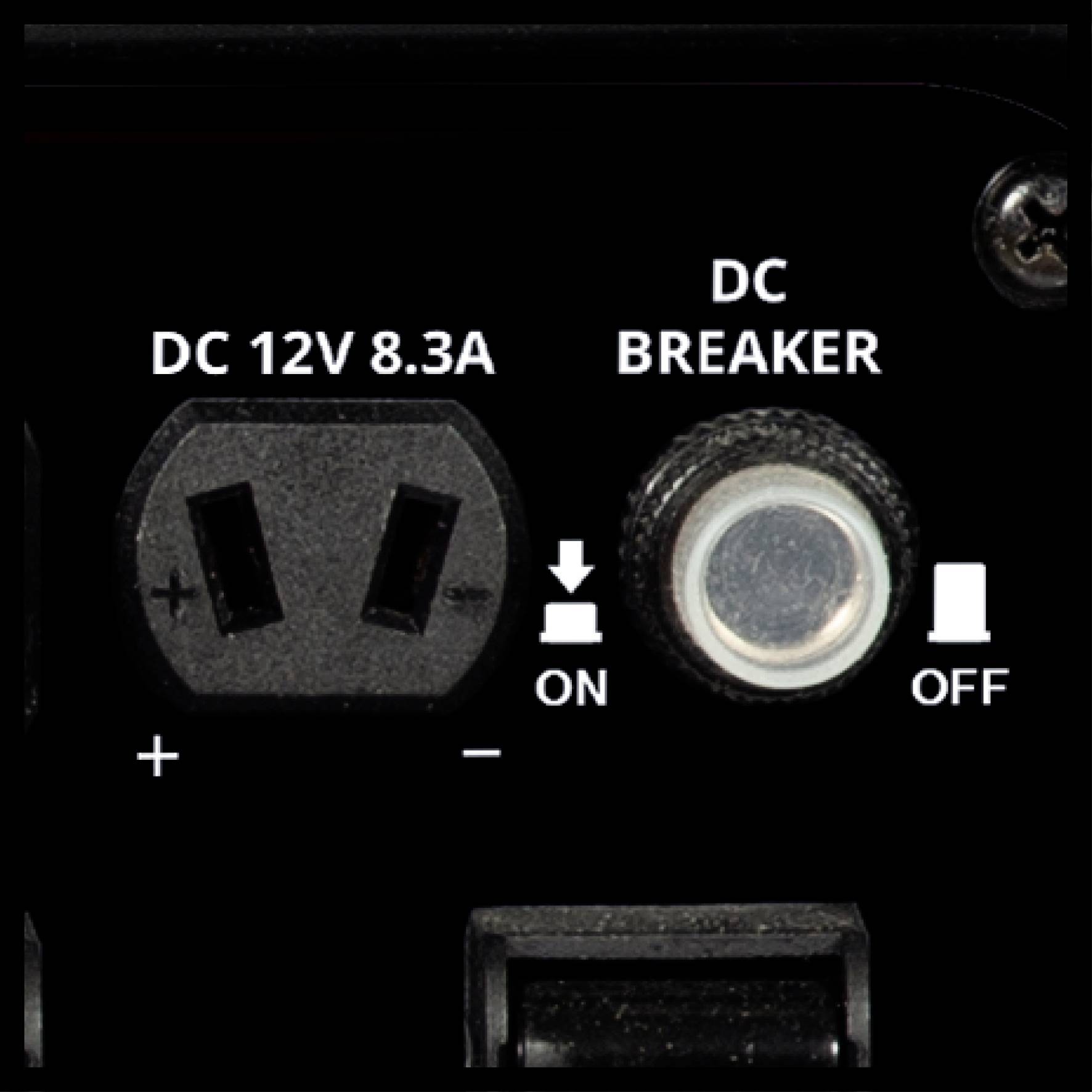 'Närbild av DC 12V 8,3A anslutning och DC-brytare. Vänster: Uttag med plus-/minusmarkering. Höger: Strömbrytare för På/Av.'