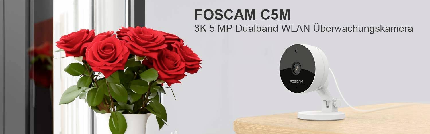 FOSCAM C5M 3K 5 MP Dubbelband WLAN-övervakningskamera bredvid en bukett röda rosor på ett bord.