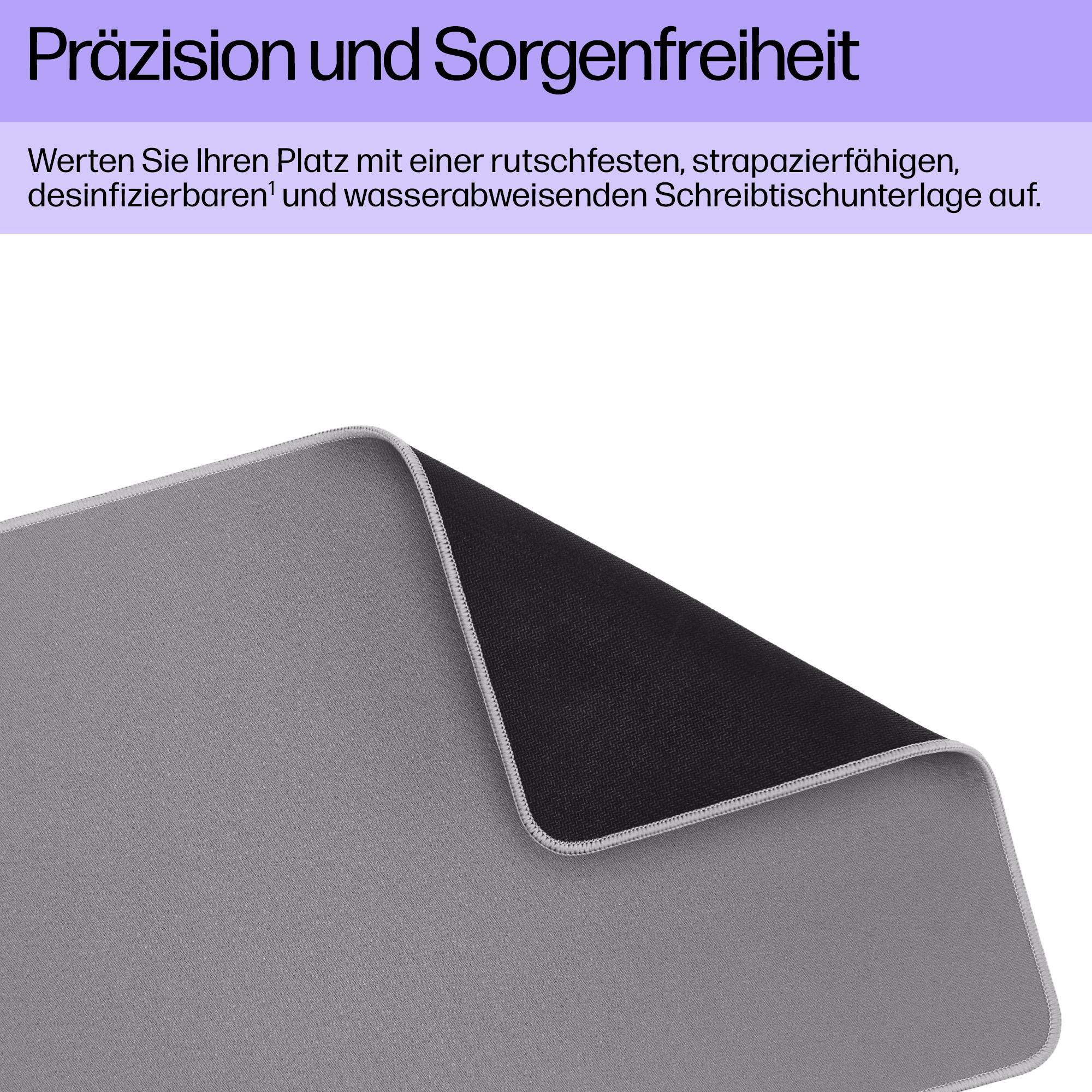 En grå skrivbordsunderlägg med svart baksida, som är halksäker och vattenavvisande, ligger lätt upprullad.